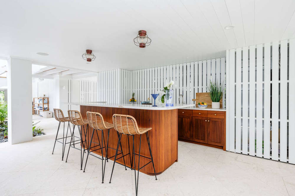 Saunders Wood Works — walnut slat bar with rattan stools